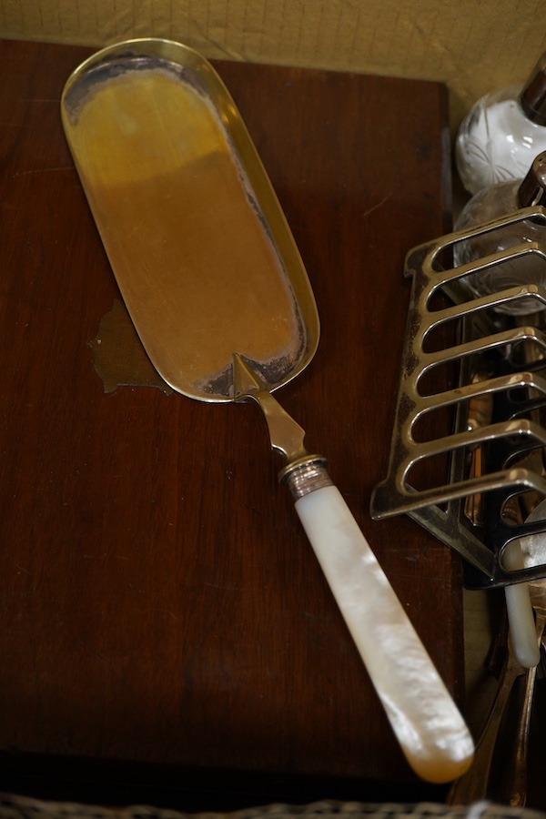 A cased set of twelve pairs of mother of pearl handled plated dessert eaters and a quantity of assorted plated items including a toastrack, a pair of mounted glass condiments, crumb scoop and miscellaneous flatware.